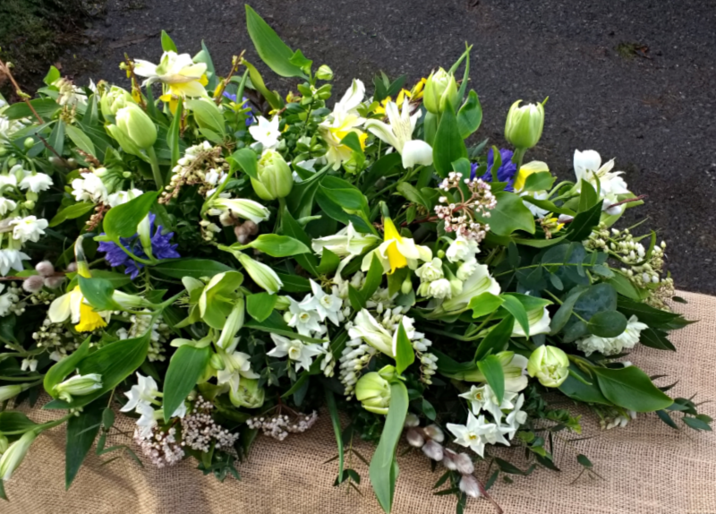 Funeral Spray of Spring Flowers including white double Tulips, White Narcissi, yellow wild Daffodils, blue Hyacinths, yellow Forsythia, Pieris, Viburnum, Alstroemeria & Pussy Willow. Copyright www.GallowayFlowers.co.uk