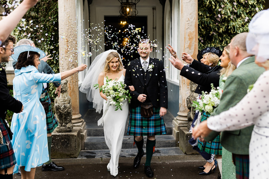 Wedding couple with shower of confetti at Auchen Castle, Flowers by Galloway Flowers, wedding flowers in Dumfries & Galloway, photo by Martin Mclellan Photography