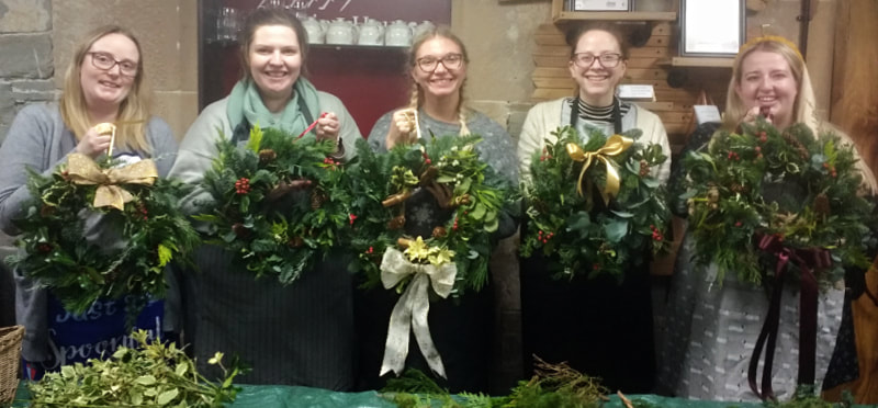 Proud wreathmakers with completed Christmas wreaths after workshop at Station House Cookery School, Kirkcudbright, Dumfries & Galloway. 