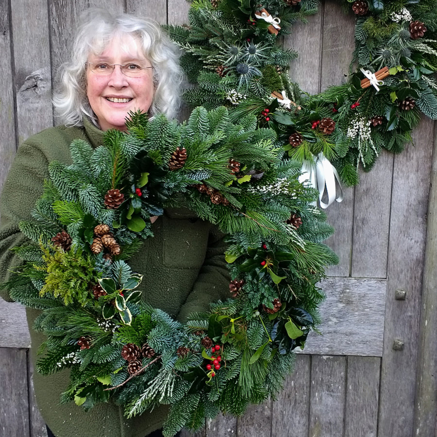 Rosie Gray, Florist & Flower Farmer in Scotland with giant hand made Christmas wreaths. Copyright www.GallowayFlowers.co.uk