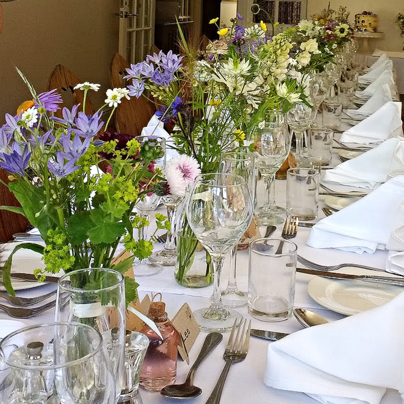 Wedding table decorated with wild flowers in bottle for a summer wedding at gretna green. wedding flower packages gretna green, wedding flowers dumfries copyright www.gallowayflowers.co.uk